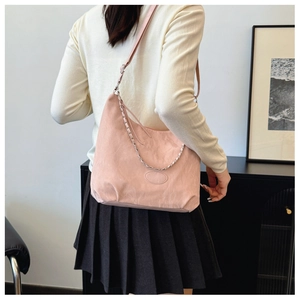 Detail of pink Hobo bag showing soft textured surface and silver chain strap decoration