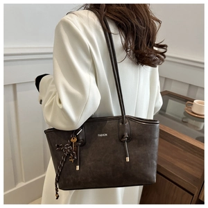 Detailed view of coffee brown tote bag with fashion lettering and side knot detail