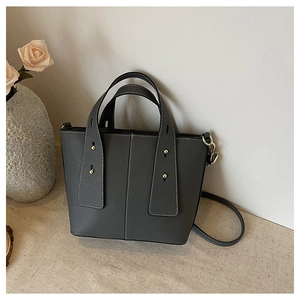 Detail view of charcoal gray lychee grain leather handbag with white contrast stitching