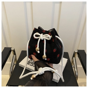 Detailed view of black corduroy bucket bag with strawberry embroidery and drawstring