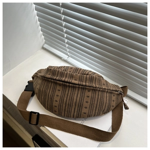 Macro detail of brown striped fabric waist bag with durable plastic buckle and strap
