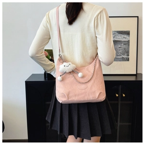 Detail of soft pink crescent crossbody bag with cute cloud pendant and metal chain accent