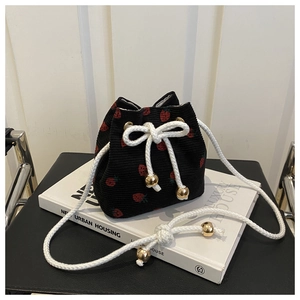 Detail of corduroy strawberry bucket bag with drawstring and gold metal beads