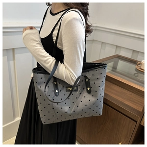 Détail du grand sac cabas gris à pois noirs avec des anses en cuir élégantes