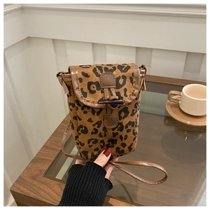 Detail of leopard print crossbody phone bag with brown leather trim and horn buckle closure