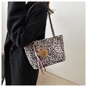 Dettaglio della borsa tote leopardata con catena dorata e ciondolo a forma di orso