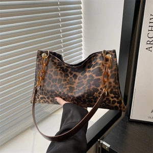 Modieuze schoudertas met luipaardprint, amberkleurige ketting en bruine leren riem