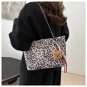Dettaglio della borsa tote leopardata con ciondolo a orsetto e tracolla a catena