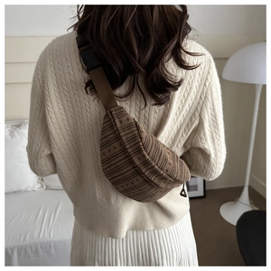 Detail of vintage striped knit crossbody bag showing texture and buckle on shoulder strap