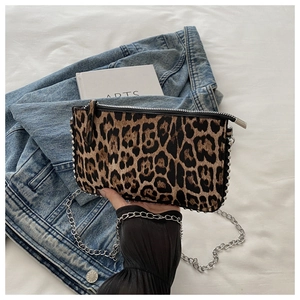 Close-up of leopard print shoulder bag with silver studs and metal chain strap details