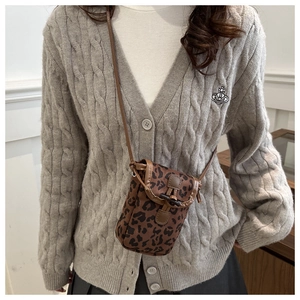 Detailed view of leopard print crossbody phone bag with vintage horn buckle and strap