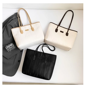 Detailed flat lay of pleated tote bags in white, beige, and black with textured stripes