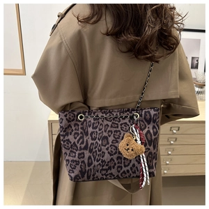 Dettaglio borsa shopper leopardata con tracolla a catena e ciondolo orsetto peluche