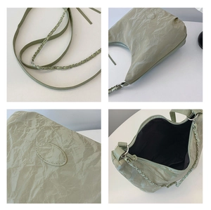 Detail of light green pleated bag featuring silver chain strap and oval stitch patterns