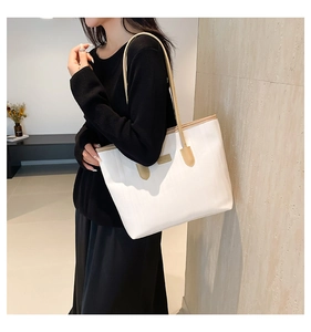 Large white textured tote bag for women shown on shoulder with slim brown straps