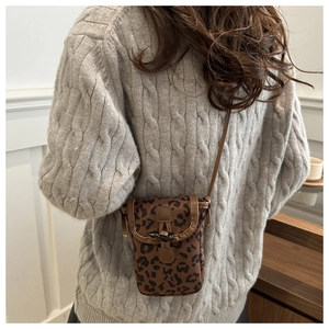 Detailed back view of a mini leopard print crossbody bag with brown leather strap