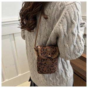 Detailed view of fashionable leopard print crossbody phone bag with horn toggle closure