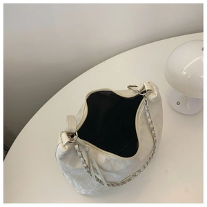 Detailed top view of the spacious black interior and zipper closure of a white pleated bag