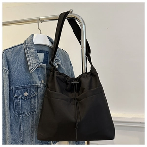 Detail view of large black drawstring oxford tote bag with two front pockets