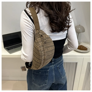 Close-up of brown vintage striped crossbody bag with star patterns and wide strap