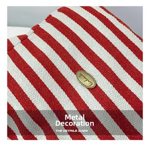 Detail of red and white striped canvas with a gold handmade engraved metal hardware plate