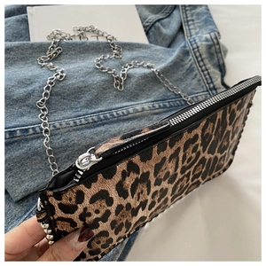 Close-up of leopard print crossbody bag with silver chain strap and zipper detail