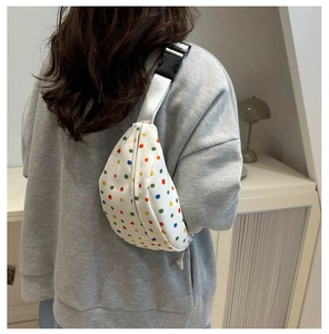 Detail of white floral belt bag with colorful polka dots and nylon strap on model