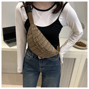Detail showing brown knitted half-moon chest bag texture and adjustable strap