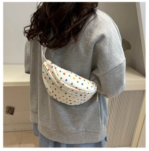 Rear view of a model wearing the white polka dot crossbody bag with colorful patterns