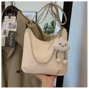 Detail of cream hobo bag with silver chain strap and a cute cloud plush charm