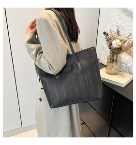Detail of black striped tote bag with leather texture and JINGPIN label on shoulder