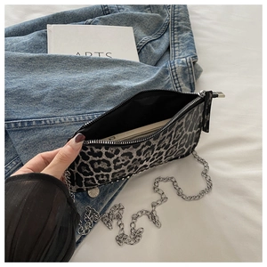 Close-up of leopard print crossbody bag showing interior capacity and silver chain strap
