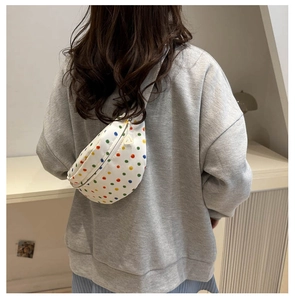 Detail of colorful polka dot canvas saddle bag with unique triangular zipper puller