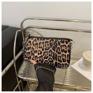 Close-up of leopard print crossbody bag with silver studs and metal chain strap