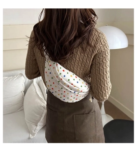 Polka dot waist bag on a brown sweater model in a minimalist home setting