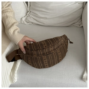 Detail of dark brown corduroy chest bag featuring soft texture and adjustable nylon strap