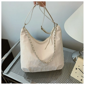 Detail of off-white pleated shoulder bag with metallic chain and adjustable strap