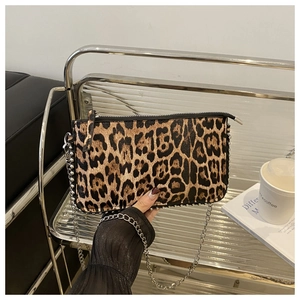 Detail of leopard print clutch featuring silver chain strap and metallic ball trim