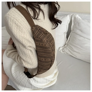 Detailed view of an ethnic style saddle bag featuring brown geometric jacquard textures