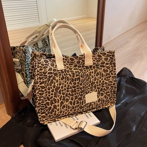 Large leopard print canvas tote bag with dual front pockets and adjustable shoulder strap