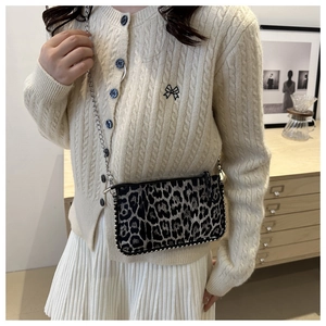 Detail view of mini leopard print crossbody bag with silver chain and stud accents