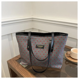 Macro view of grey star printed tote bag with leather handles on a glass table