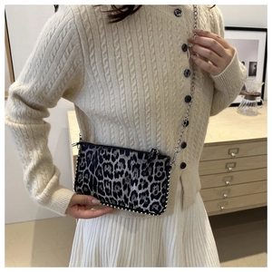 Detail of leopard print shoulder bag with silver studs and metal chain strap