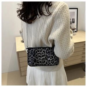 Detail of leopard print crossbody bag with silver metal studs and elegant chain strap