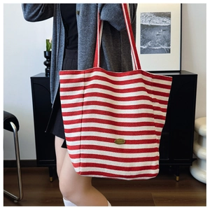 Detail of red and white striped canvas tote bag with handmade oval logo patch