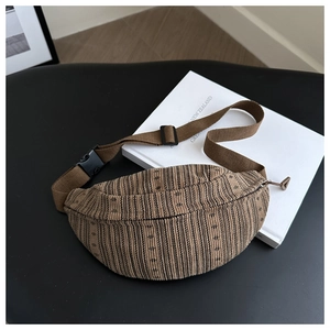 Detail of brown vertical stripe texture and adjustable strap on high-capacity chest bag