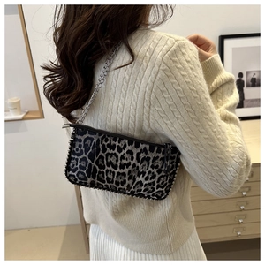 Detail of leopard print underarm bag with silver chain strap and metal rivet trim