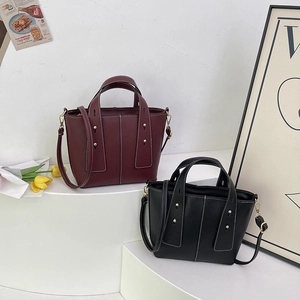 Litchi pattern leather handbags in burgundy and black with wide straps and metal studs