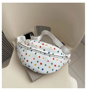 Detailed view of white canvas crossbody bag with colorful polka dots and adjustable strap