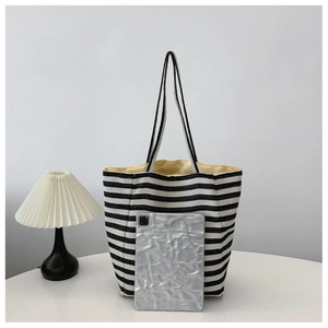 Striped canvas tote bag detail showing interior capacity with a tablet for size reference